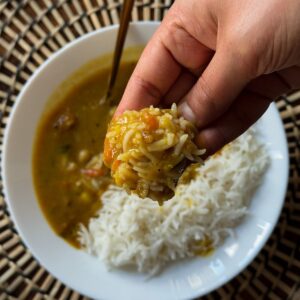 gujarati dal bhath in a bowl eating with hands