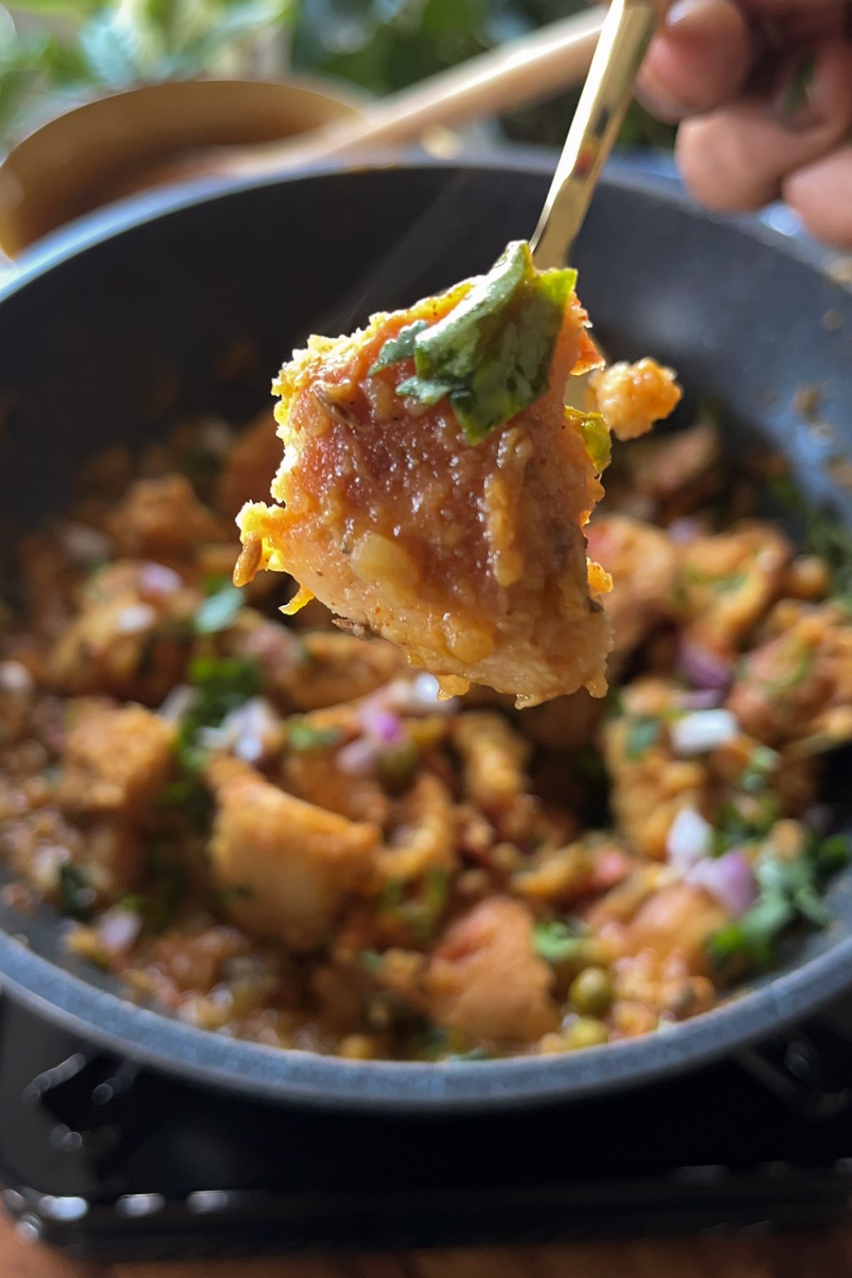 masala pav held with a fork out from a wok